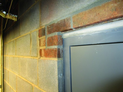 Steel lintels (seen above the door) sit on top of the corner bricks and support the brickwork on both sides of the door.