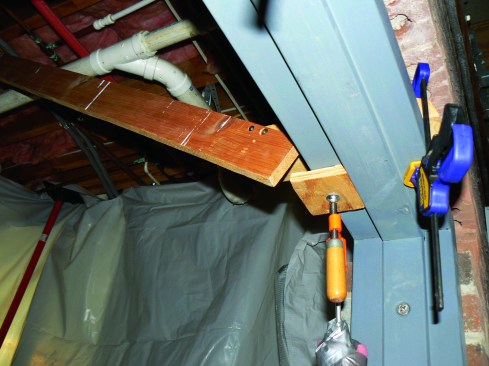Braces clamped to the frame and attached to the joists hold the door frame in place.