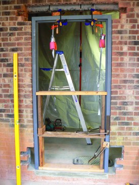Spreaders keep the jambs from bulging inward while the brickwork and grouting is completed.