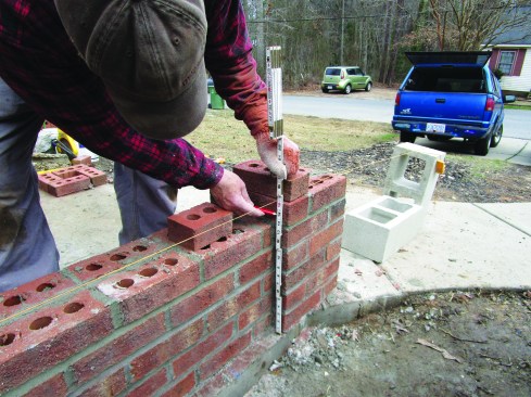 After laying up six courses on the column, the author made a mark 15 inches above the concrete base.