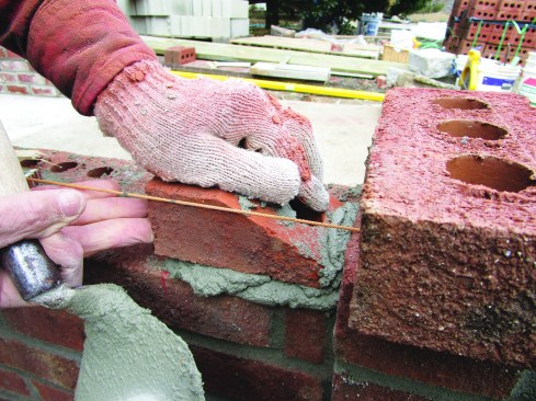 The author set the angled brick in mortar along the stretched course line.