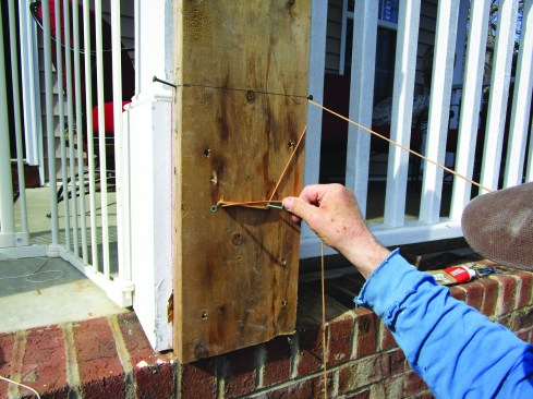 At the top, he attached the lines to the sides of a board ripped to 7 5/8 inches (the width of the wall), anchoring them to a makeshift cleat.