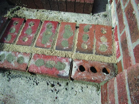 To provide drainage, the author left the head joints in the lowest course of the stairs unmortared, with sand keeping the bricks behind that course clear of mortar droppings.