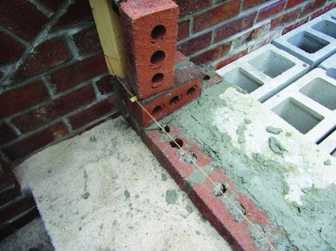 He clipped twigs over the line at each end and held the twigs in place with bricks.