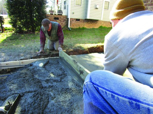 The sidewalk height was close to being right for the slab. The crew used a straight 2-by to screed the concrete even with the sloping forms.