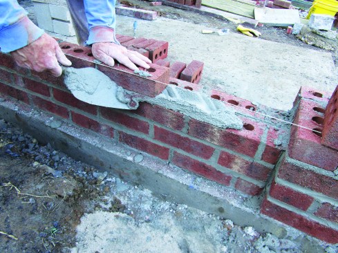 The author lays bricks to the line.