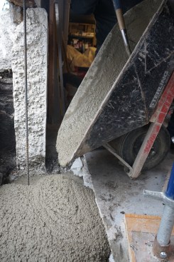 The crew kept dumping batches of wet concrete into the trench until the footing was level with the basement slab. 