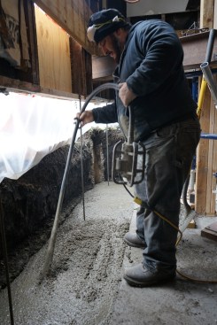 To remove air bubbles in the mix and to create the densest possible concrete for the footing, the crew vibrated the wet concrete mix after filling up the footing trench.