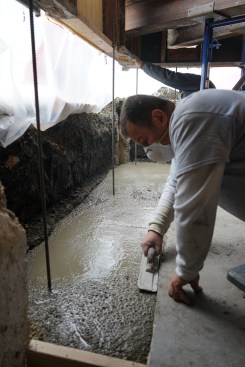 Vibration not only consolidated the concrete, but also brought more liquid tot he surface, making it easier for the crew to smooth the wet concrete surface of the footing with a float. 