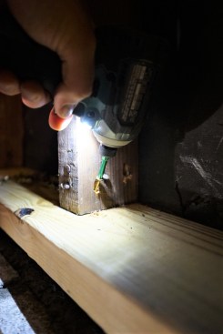After pushing the sill stock tight against the bottoms of the studs, the crew drove galvanized toe screws through each stud and into the sills to hold the sills in place.