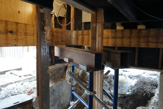 After making openings in the sheathing, the crew inserted the needle beams and supported them inside with double screw jacks. 
