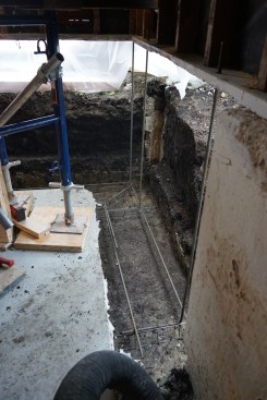 The rebar in the footing was wired together with vertical rebar that extended up through holes in the existing sill plates (which would later be replaced), tying the footing to the concrete-block replacement foundation. 