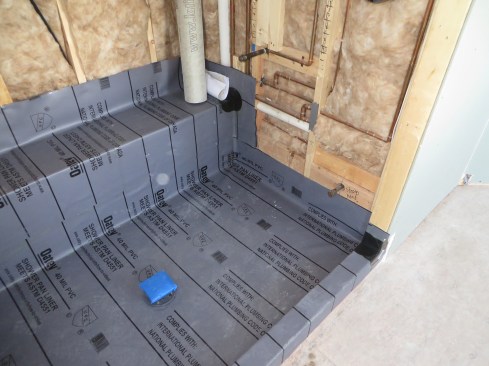 The steam head, at the lower right corner of the shower wall, is roughed-in at 12 inches above the finish floor and 12 inches from a future glass wall panel.