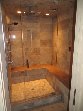 A plastic fan (visible behind the ceiling-mounted rain head) will help clear moisture from this enclosure.