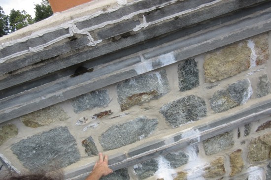 Efflorescence-stained stone veneer indicates that a lot of water had moved within the masonry chimney.
