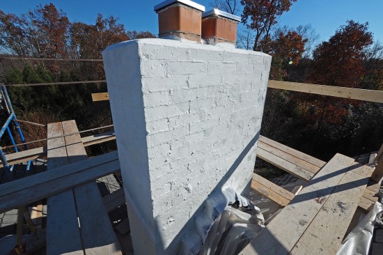 A waterproof cement-based coating (MasterSeal 581) is applied up and over the block chimney core.