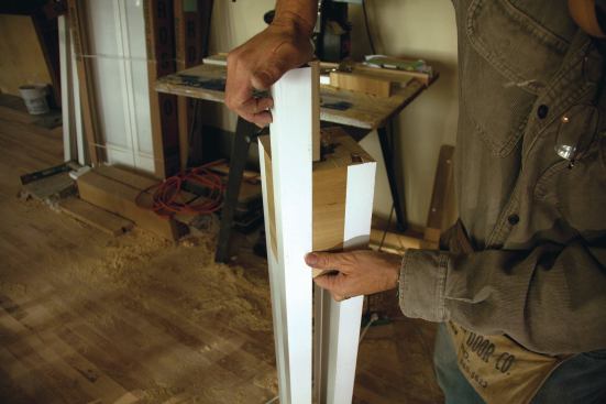 Three of the four corner pieces were glued and screwed through the edge of the infills to minimize the number of visible fasteners; the fourth was installed by applying yellow glue to the backers, sliding the corner piece into place from the top down, and clamping it.