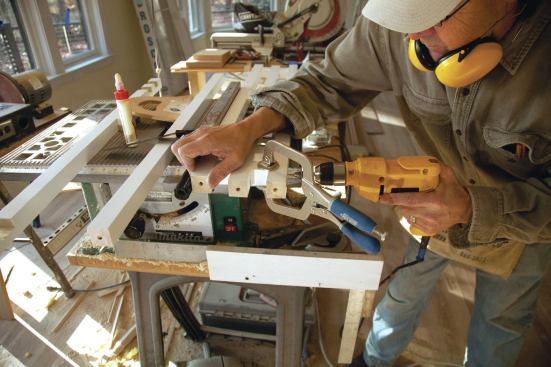 Once the baluster ends were aligned, the cross blocks were clamped in position while screws were countersunk into the balusters and driven into the end grain of the blocks. After the balusters were installed on the treads, the screw holes were plugged, sanded flush, and painted. 

