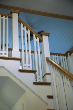 Newels at the landing and second floor are simple 4x4 posts with smaller custom caps.