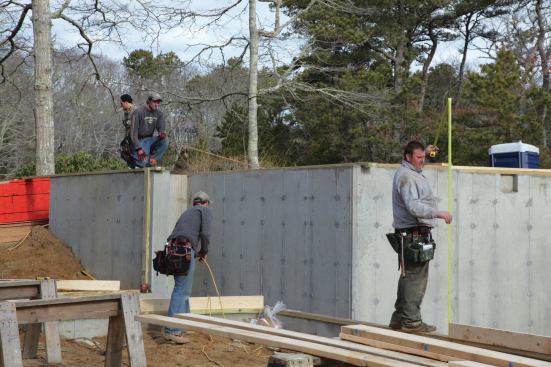 I begin by cutting in the plates for each individual wall section and determining the stud height. To get a stud height we use a laser to shoot a line across the rear of the house and check measurements every 8 feet.