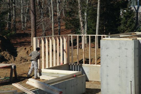 As we're installing the steel, the other crew members stand up the shorter of the drop walls and nail them off to the sills.