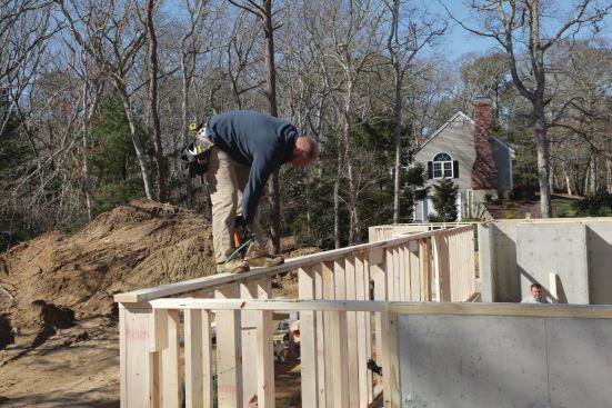 To give us one set height for the entire first-floor deck, we align the first (lower) top plate on the drop wall with the PT sill on the full-height foundation walls. Then we run a second KD sill plate around the perimeter of the foundation that laps onto the drop walls as the second top plate.