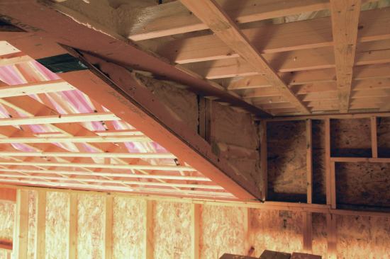 At the dormer in the middle of the house, the ceiling is framed flat with the OSB strips around the perimeter.