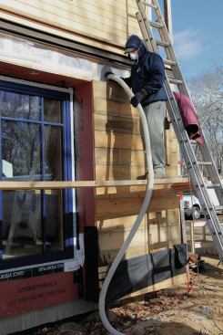 Rockwool insulation made from molten rock that has been spun into fiber is dense-packed into the wall trusses.