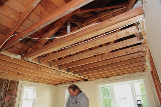 As the insulation fell away and the existing framing was exposed, the trouble mentioned earlier found us. When the addition had been built, a structural valley had been added to just one side. The valley framing on the other side was a hybrid, with a structural valley meeting a doubled rafter, and a "California valley"—with one roof resting on the other—continuing the rest of the way.