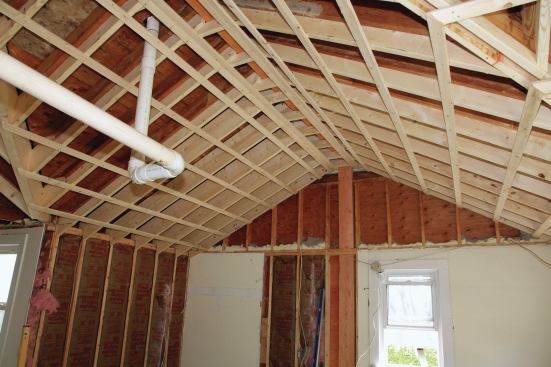 With all the new rafters in place and both ends of the ridge supported on posts, the crew ran furring strips over the whole ceiling and filled in the framing above the bathroom walls and over the flat ceiling.