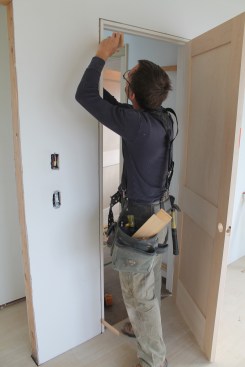 Insert shims just behind the jamb leg just below the head jamb.