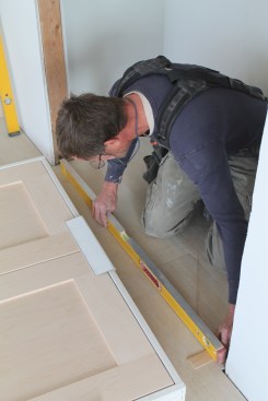 For a double door, first check the opening. If the floor isn't level, shim under the level until the bubble is in the middle.