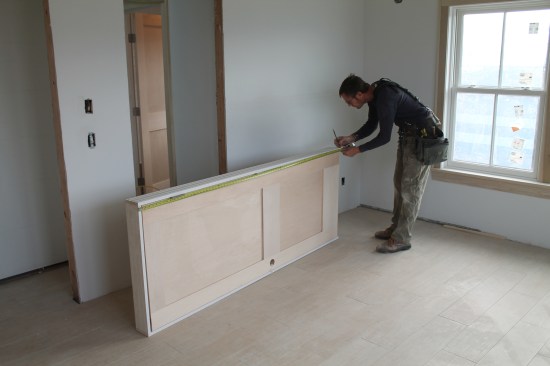 Keeping the temporary fasteners in place tht hold the door assembly together, start by marking the length of the jamb leg on one side.