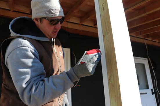 A generous bead of glue is applied to both sides of the post wrap.