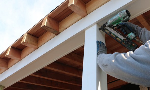 The wraps are made to go around the treated 4x4 posts and to fit inside the beam trim above. Nails hold the wrap in place while the fourth side is installed.