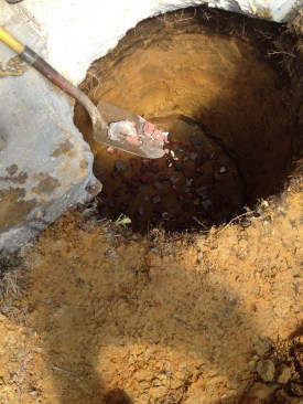 A layer of crushed stone was added to the bottom of the hole to support the footing and to keep the pump clear of the bottom of the hole.