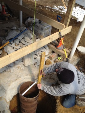 With the form sitting in the hole, the author centers it and plumbs it for the pour.