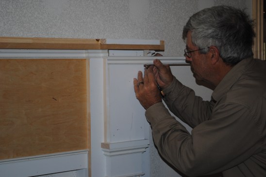 Panel molding tops the pilasters below the mantel shelf. The author marks the length of each piece of molding in place.
