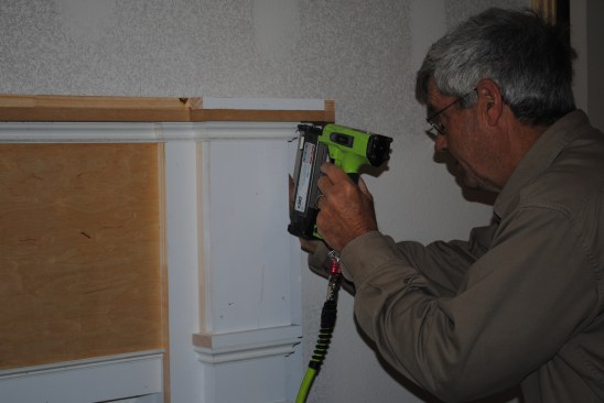 He then nails each piece onto the mantel.