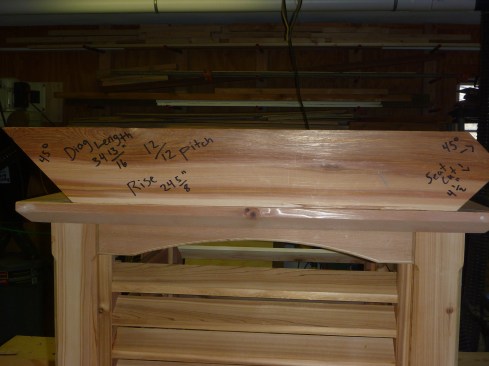Author laid out and cut a pattern rafter out of 2x cedar stock. The rafter will slant up at a 45° angle from the corner of the louvered section and meet the other rafters in the center. 