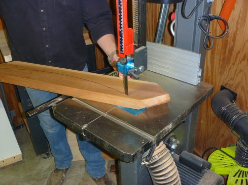 A bandsaw cuts the curve in each of the rafters.