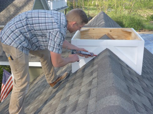 A bead of silicone seals the slanted edges of the base to the roof, but the bottom horizontal edges were left clear to allow moisture to drain away.