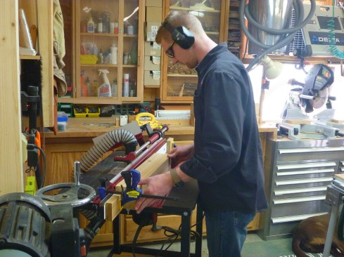 After cutting four posts for the corners of the louovered section of the cuopla, the author chamfers the edges of posts on a router table. Stops clamped to the fence govern the amount of each edge that receives a chamfer.