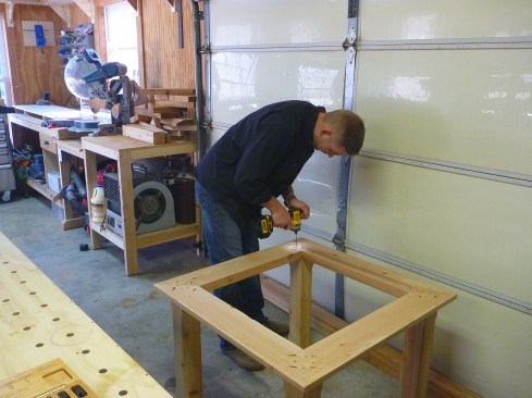 After flipping the assembly over, long screws attach the frame to the posts.