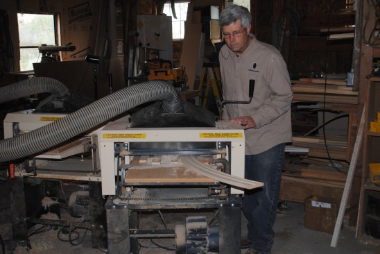 Cutter knives attach to the planer head to create the profile of the curved molding.