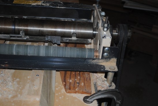 The cover is removed from the machine to show the setup for the panel moldings for the back panel. The guides screwed to the temporary table allow the author to mill both curved and straight moldings with the same set-up. 