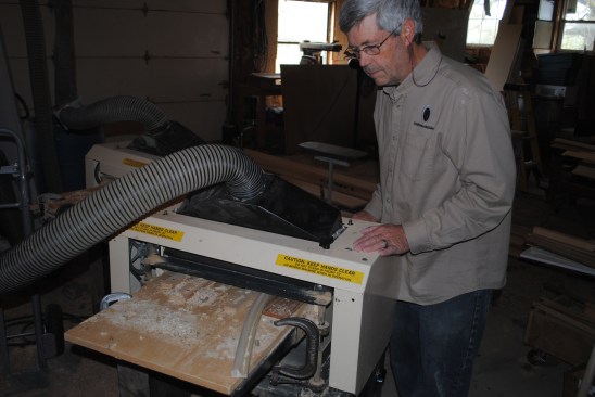 Here the author feeds the stock through the planer for the molding for the back panel that had to be profiled on the flat.