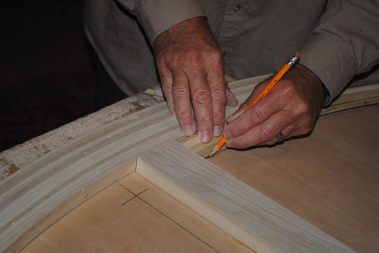 To lay out the panel molding for the back panel, the author uses a short piece of molding to draw lines that will help to precisely determine the angles of the adjoining pieces. 
