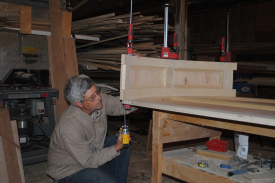 When the curved top is finished, the author clamps it in place on the back panel and joins them together with screws.