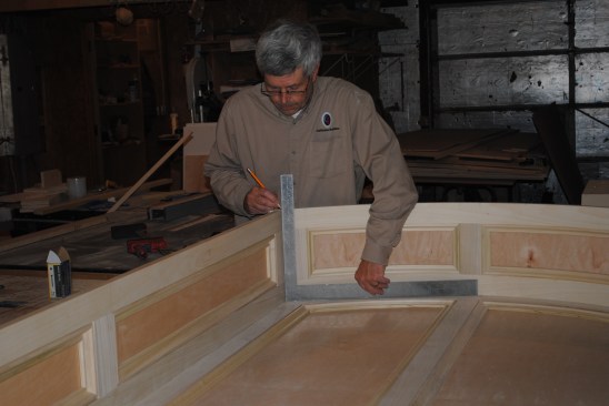 The author uses a framing square to align the side panel square to the back panel and marks the position on the curved top.